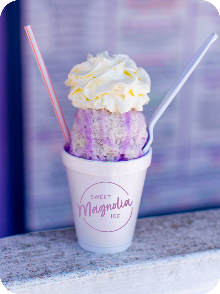 Person holding Sno-Ball with whip cream on top